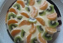 Торт украшенный рожком черникой абрикосом апельсином и киви